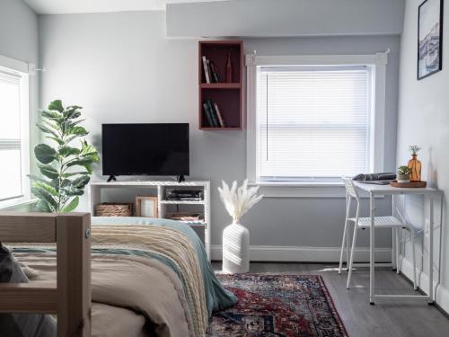 a bedroom with a bed and a desk and a television at Historic Townhouse - Heart of Little Italy in Baltimore