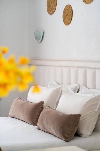 a white bed with a bunch of pillows on it at Golden Tulip Président Hammamet in Hammamet