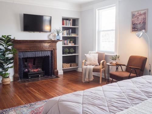 a living room with a fireplace and a tv at Historic Townhouse - Heart of Little Italy in Baltimore