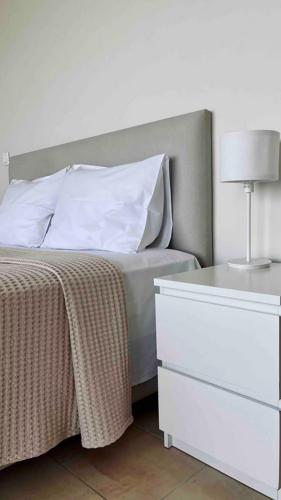 a bedroom with a bed with a dresser and a lamp at Enchanting Sea View in Kallithea Halkidikis