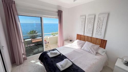 a bedroom with a bed with a view of the ocean at Primera linea de playa en Torrox Costa in Torrox Costa