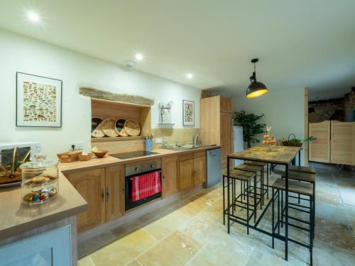 une grande cuisine avec des placards en bois et une table dans l'établissement Le Gentil Coquelicot, à Monpazier