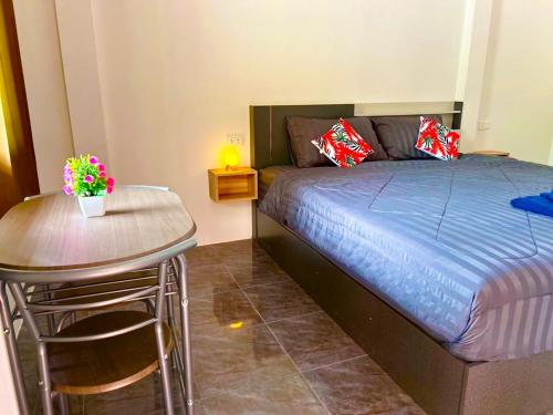 a bedroom with a bed and a table and a table and chairs at Palm Tree Resort in Ao Nang Beach