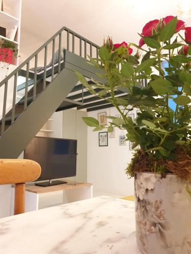 un vase avec une plante sur une table et un escalier dans l'établissement Bel appartement - Jardin des plantes, à Paris