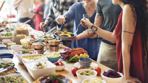 a group of people standing around a buffet of food at Crowne Plaza Doha - The Business Park by IHG in Doha