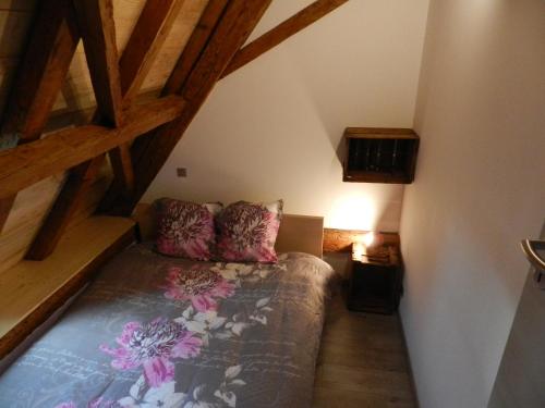 um quarto com uma cama num sótão em Gîte autonome, La grange a foin, piscine ! em Bergholtz