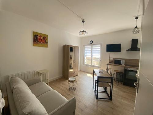 un salon avec un canapé et une table dans l'établissement Charmant Studio Rêves de Mer 101, à Fort-Mahon-Plage