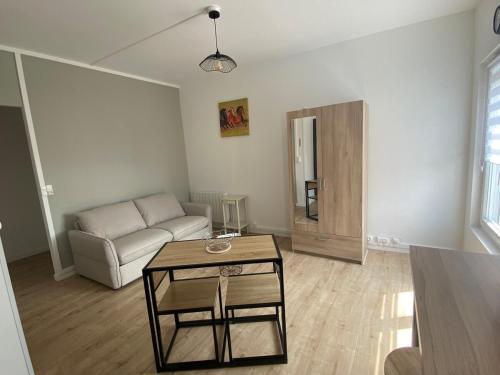 un salon avec un canapé et une table dans l'établissement Charmant Studio Rêves de Mer 101, à Fort-Mahon-Plage