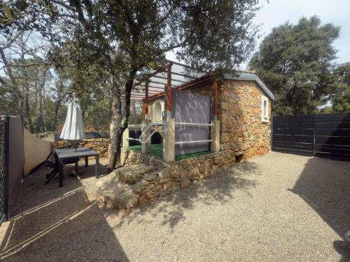 ein winziges Haus mit einer Steinmauer in der Unterkunft votre Cocon en pierre et son spa en option gîte le repos des chênes in Régusse