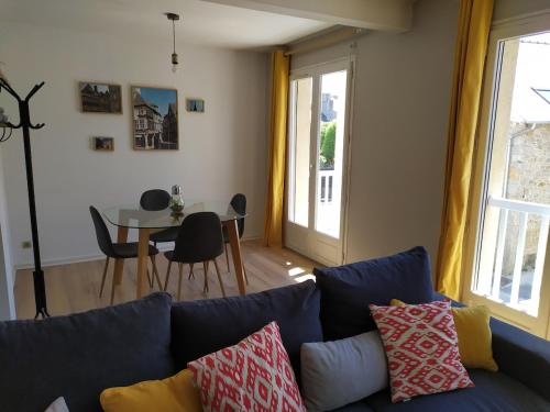 un salon avec un canapé bleu et une table dans l'établissement Appartement WILTON, à Dinan