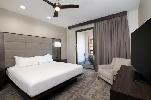 a hotel room with a bed and a chair at Hilton Promenade Branson Landing in Branson