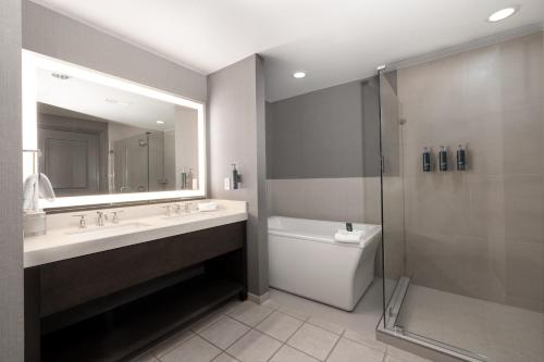 a bathroom with a sink and a shower and a toilet at Hilton Promenade Branson Landing in Branson