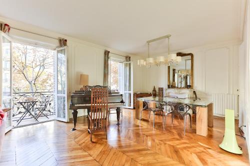 un salon avec une table et un piano dans l'établissement Appartement 140m2 proche des Champs Elysées, à Paris