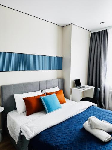 a bedroom with a large bed with colorful pillows at Студия Aport in Pokrovka