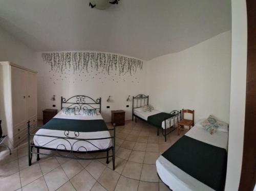 a bedroom with two beds and a chandelier at Mariposa B&B in San Vito lo Capo