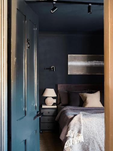 a bedroom with a bed and a blue wall at Cambridge House in Windermere