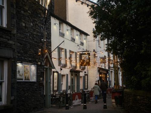 a couple of people walking down a street with buildings at Cambridge House in Windermere