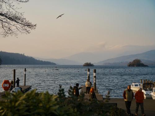 a group of people standing on a dock near a body of water at Cambridge House in Windermere