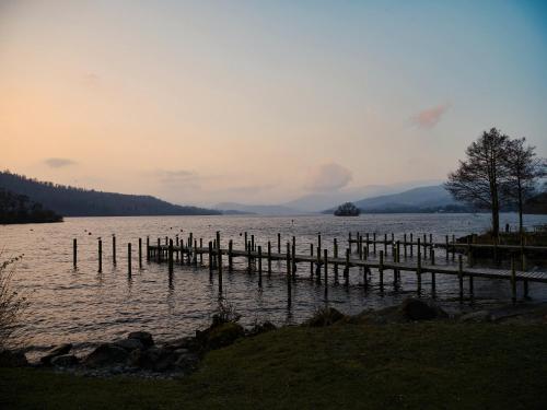 a large body of water with a wooden dock at Cambridge House in Windermere