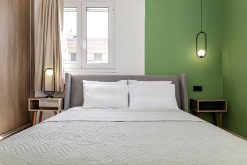 a bed in a room with a green wall at Villa Fyllo - Private Pool & Steps from the Beach in Tavronitis