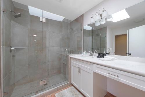 a bathroom with a shower and a sink and a mirror at Casitas Del Sol in Cathedral City
