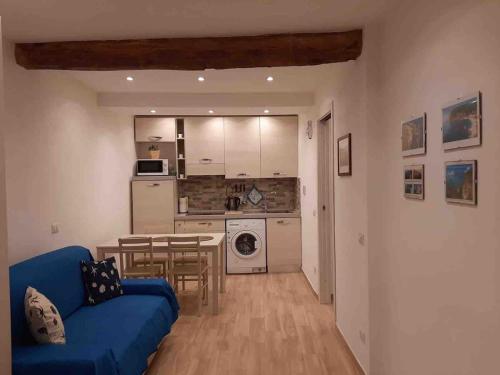 un salon avec un canapé bleu et une cuisine dans l'établissement Riomaggiore-lovely and modern apartment, free WIFI, à Riomaggiore