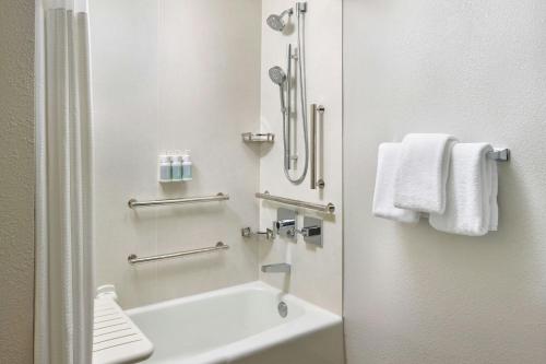 a bathroom with a tub and a sink and towels at Courtyard by Marriott Philadelphia Lansdale in Lansdale