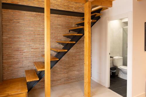 a brick wall with wooden stairs in a room with a toilet at Carthago Suites - Puerto in Cartagena