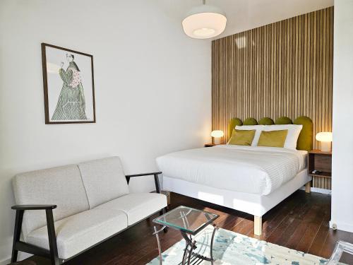 un salon avec un lit et un canapé dans l'établissement Ardoines Suite - Duke Housing, à Vitry-sur-Seine