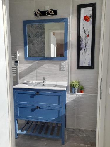 une salle de bain avec un lavabo bleu et un miroir dans l'établissement Joli appartement 2 à 4 personnes, à Vals-les-Bains