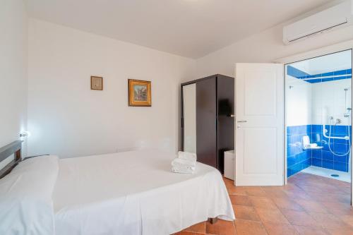 a white bedroom with a bed and a shower at Al Palmento Relais in Siracusa