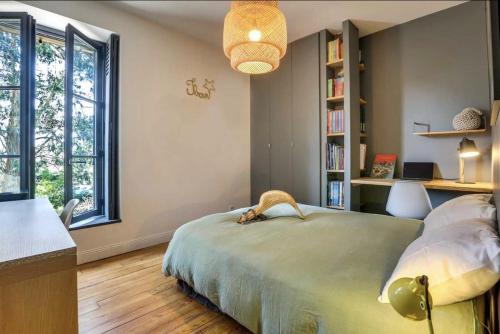 une chambre avec un lit, un bureau et des fenêtres dans l'établissement Maison Biarritz, à Biarritz