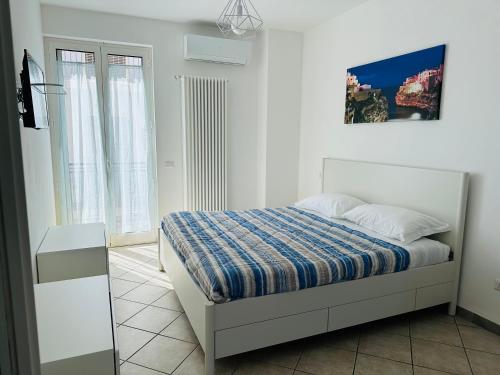ein weißes Schlafzimmer mit einem Bett und einem Fenster in der Unterkunft Terracielo Home casa vacanza privata in Polignano a Mare