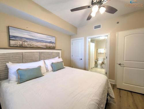 una camera con letto bianco e ventilatore a soffitto di Azure #404 Luxurious 4BD Beachfront Condo a Fort Walton Beach