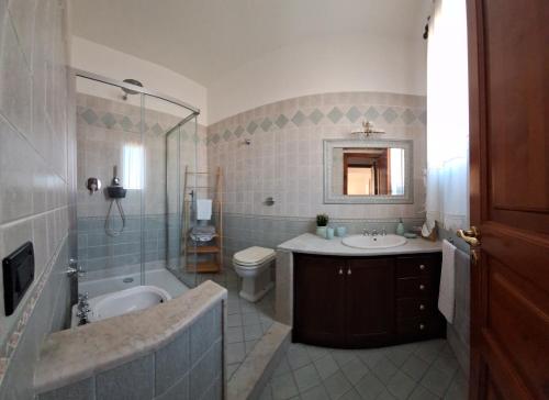 a bathroom with a tub and a sink and a toilet at Mariposa B&B in San Vito lo Capo