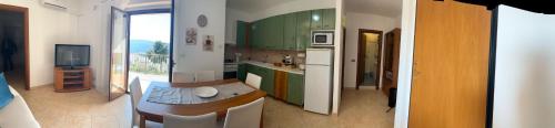 a kitchen with green cabinets and a kitchen with a table at La Casa di Caterina in Peschici