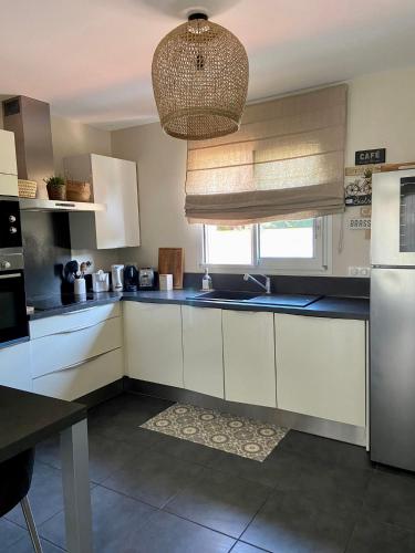 une cuisine avec des placards blancs et un plafond dans l'établissement Belle maison T4 au calme - Jardin & Parking, à Tournefeuille