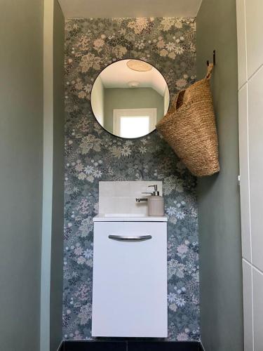 une salle de bain avec un lavabo et un miroir au mur dans l'établissement Belle maison T4 au calme - Jardin & Parking, à Tournefeuille