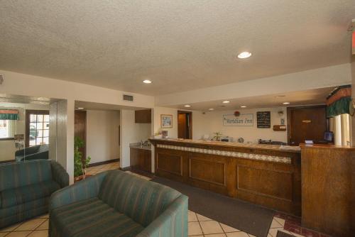 un gran vestíbulo con una sala de espera con un bar en Meridian Inn Oklahoma City Airport, en Oklahoma City