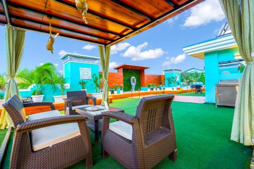 a patio with a table and chairs on a green lawn at MyOtel - Santacruz in Mumbai