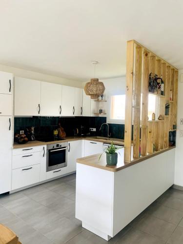 une cuisine avec des armoires blanches et un comptoir dans l'établissement Charming Quiet House in Soorts Hossegor - Pedebert Area -- Certified 3 stars Holiday Home, à Soorts-Hossegor