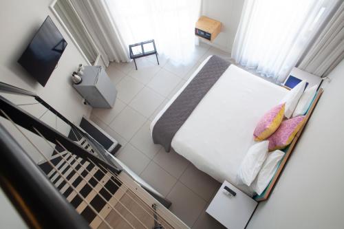 a view of a bedroom with a bed and a television at Mojo Hotel & Market in Cape Town
