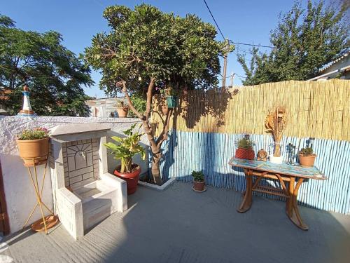 a patio with a table and potted plants and a fence at Blue Dolphins 2 bedroomed house with court yard in Skiathos Town