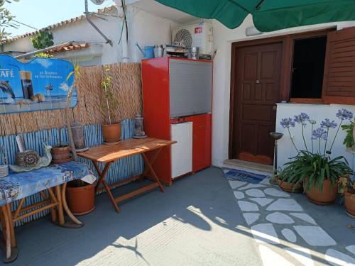a kitchen with a red refrigerator and a table at Blue Dolphins 2 bedroomed house with court yard in Skiathos Town