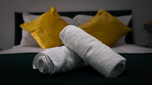 una pila di asciugamani sopra un letto di Luxury One Bedroom Flat - Cardiff City Centre a Cardiff