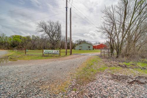 a dirt road with a fence and a red barn at Outdoorsy Getaway Near Atoka Hunt, Fish and Relax! in Atoka