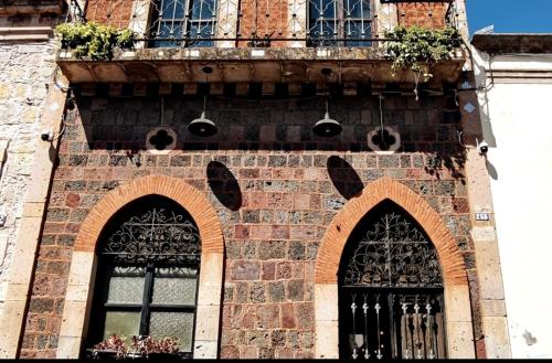 a tall brick building with two windows and a balcony at Mudejar in Morelia