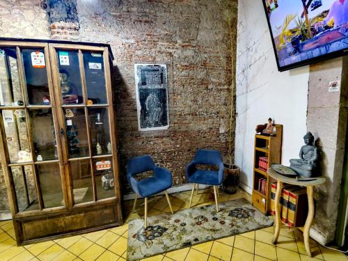 a room with two blue chairs and a table at Mudejar in Morelia