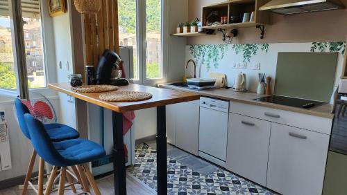 une cuisine avec un comptoir et une chaise bleue. dans l'établissement Joli appartement 2 à 4 personnes, à Vals-les-Bains