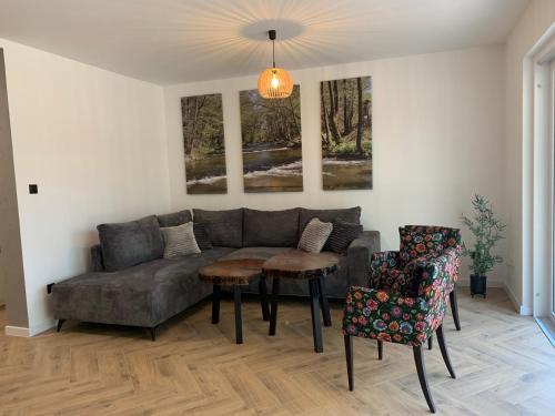 a living room with a couch and a table and chairs at Domy Leśne Szumy na Roztoczu in Zwierzyniec
